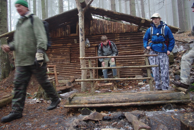 Vlk, Vojta a Michal před dřevěným srubem